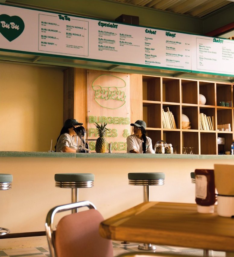 BuBu Burger: el mostrador, con la carta escrita en la pared y dos personas atendiendo detrás de la barra.