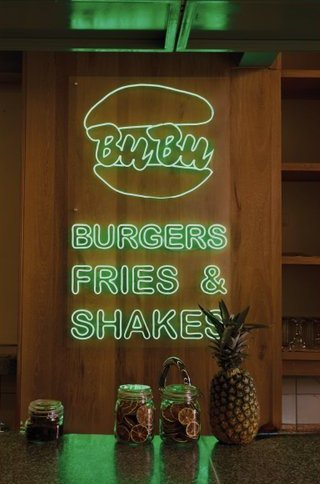 BuBu Burger: el letrero de neón verde que dice Burgers, Fries & Shakes, con una piña debajo.