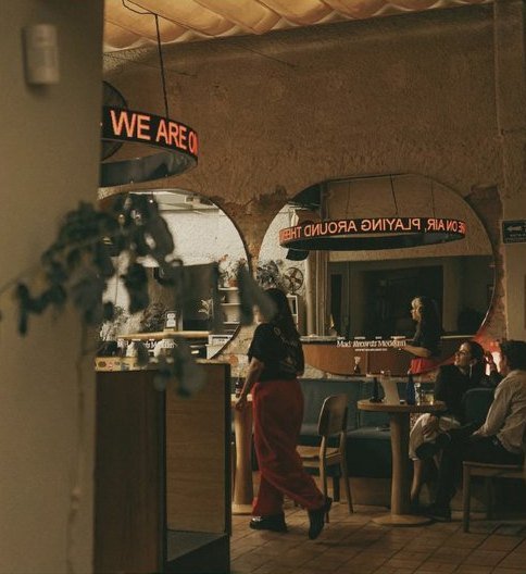 Mad Records: el interior con el letrero de neón que dice We Are y gente en las mesas.