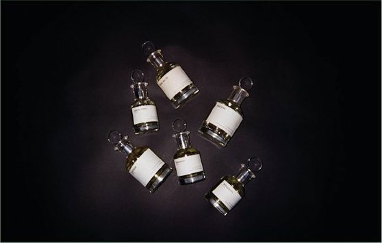 NNT Lab: frascos de perfume dispuestos sobre un fondo negro.